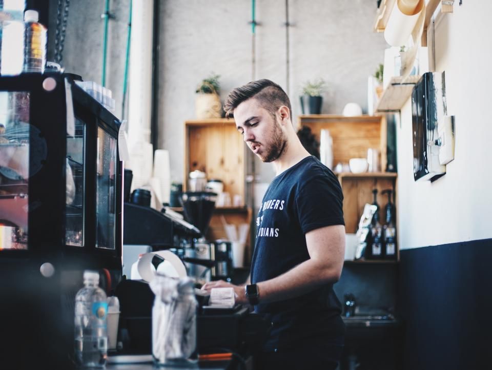 Barista préparant une commande derrière le comptoir d’un café