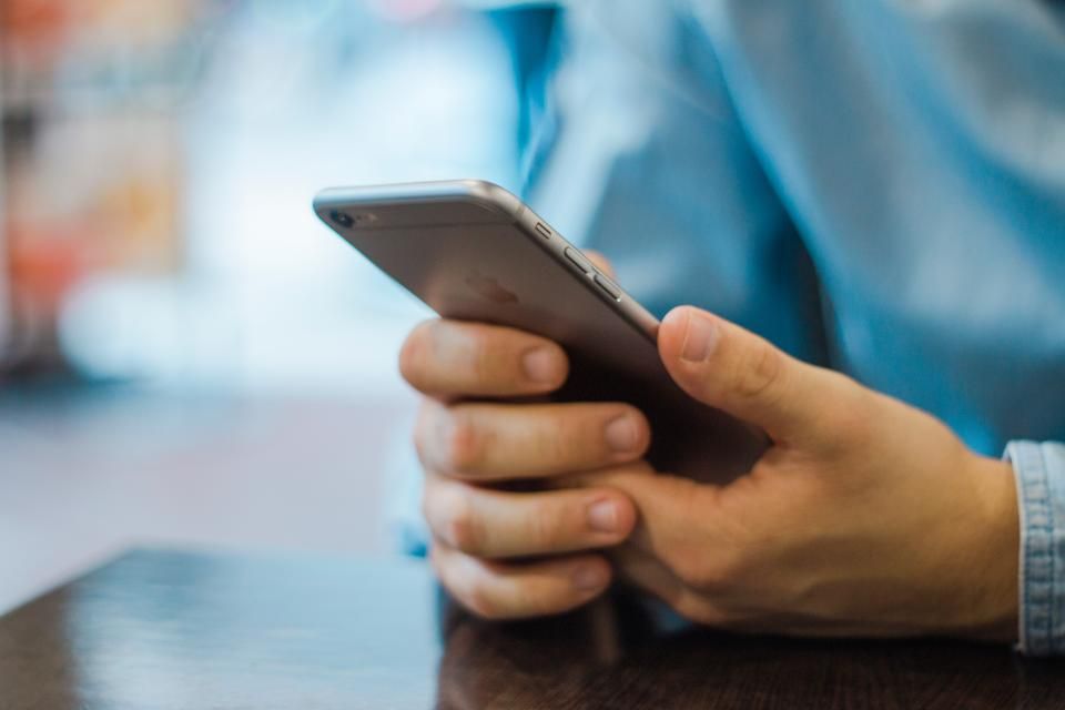 Utilisateur testant une application mobile sur smartphone