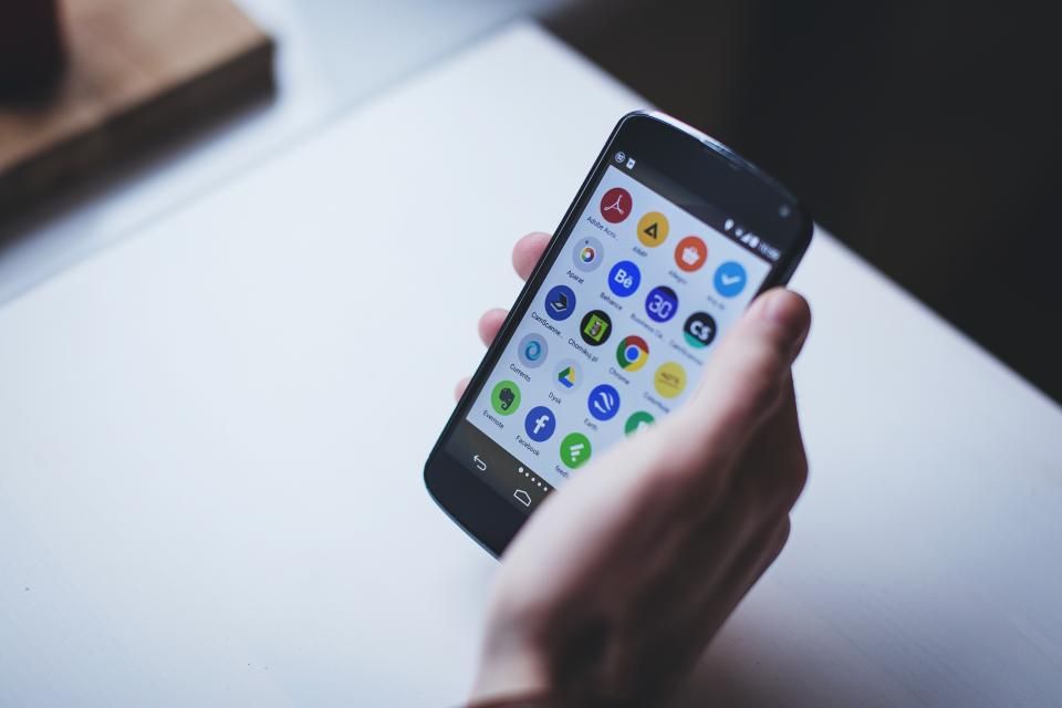 Smartphone Android tenu en main affichant des applications mobiles
