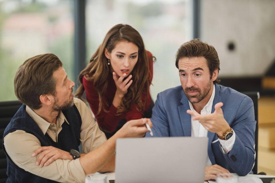 Équipe de développement logiciel en réunion de travail autour d’un ordinateur portable