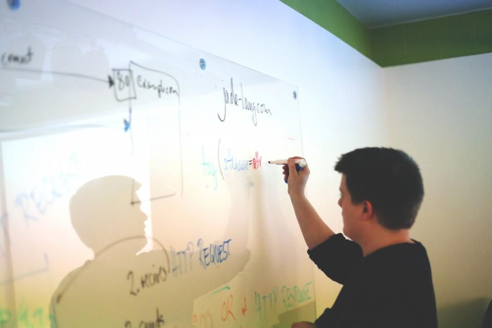 Personne présentant les étapes d’un projet d’application sur un tableau blanc