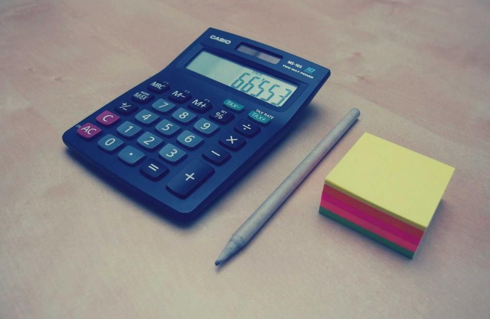 Calculatrice, crayon et bloc-notes sur un bureau
