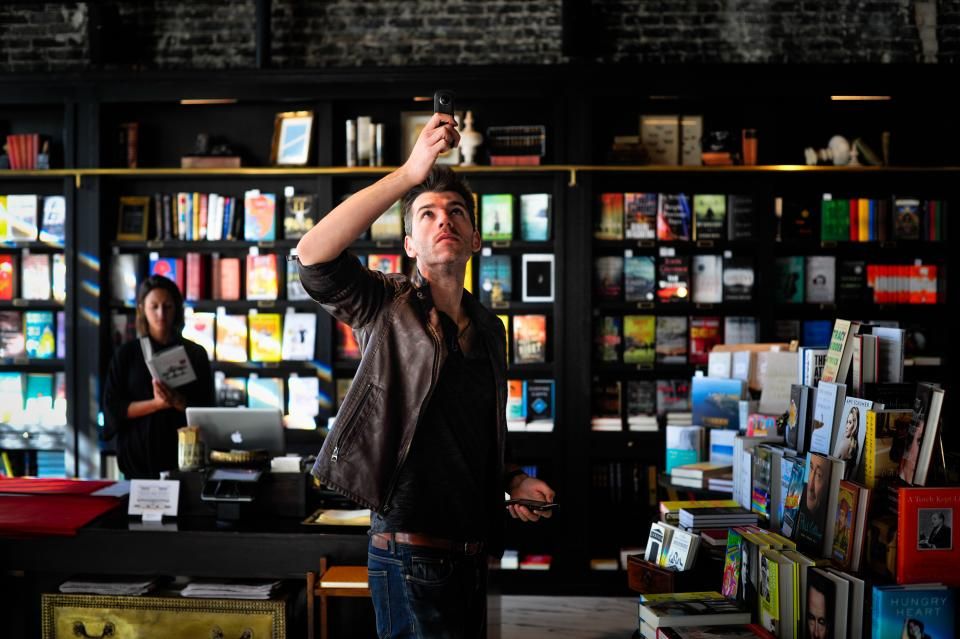 Commerçant réapprovisionnant les rayons de sa boutique