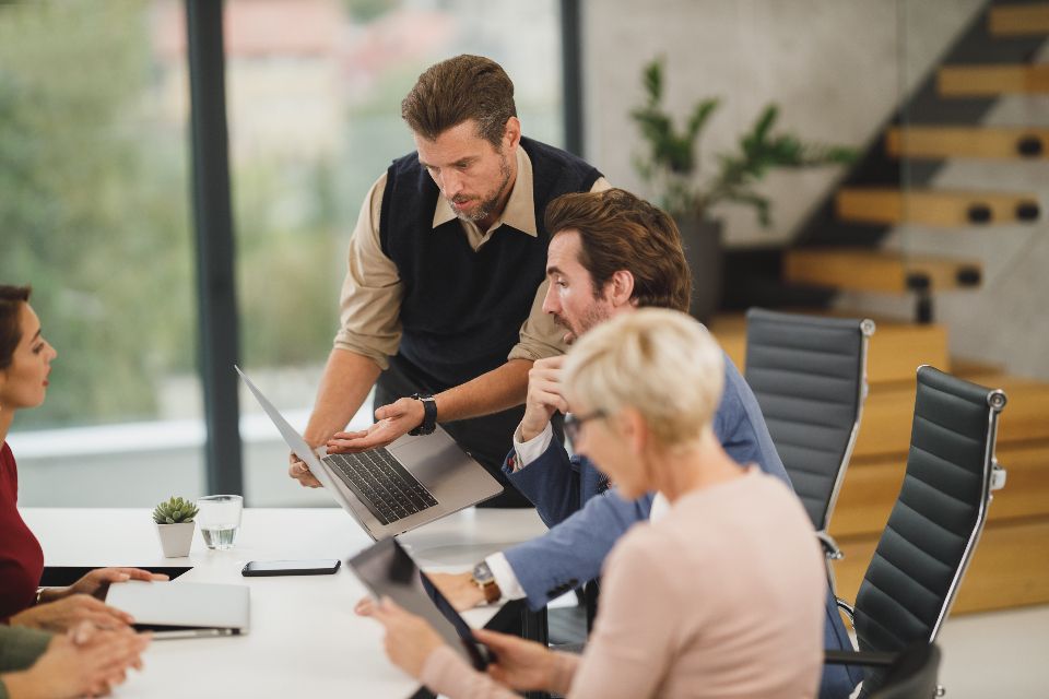 Équipe réunie autour d’ordinateurs pour concevoir un logiciel sur mesure