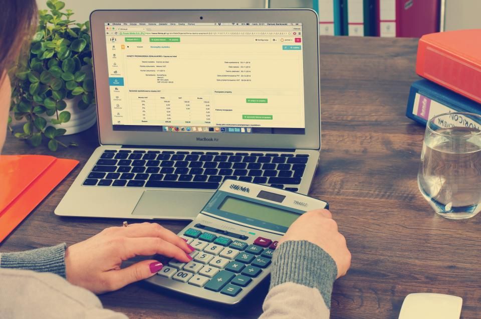Gestionnaire saisissant des factures sur ordinateur avec une calculatrice