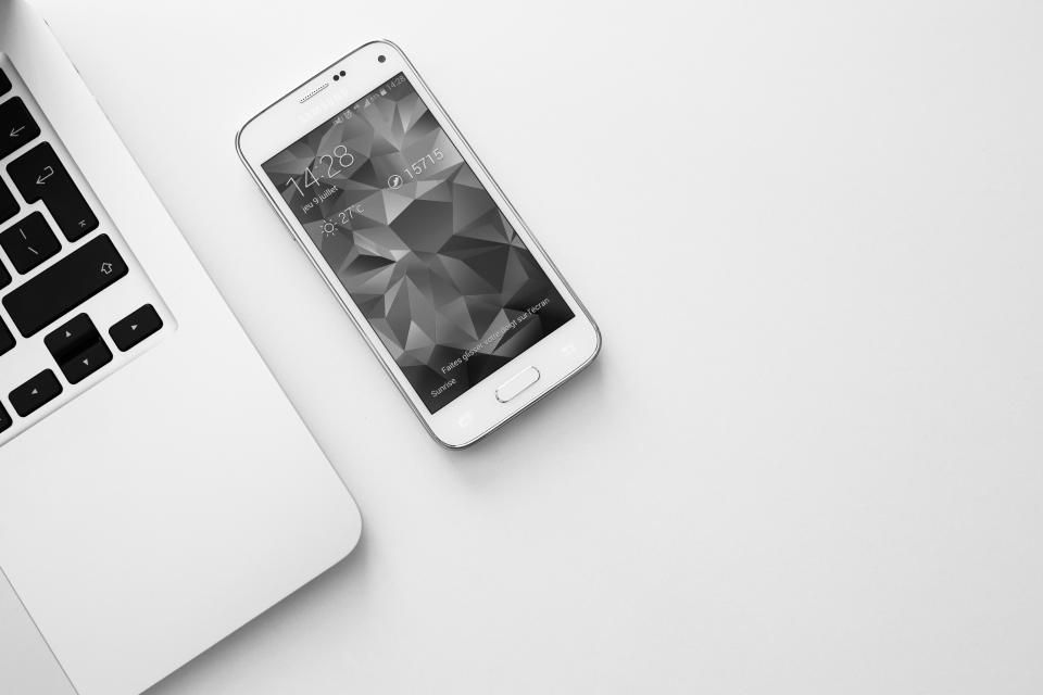 Smartphone posé à côté d’un ordinateur portable