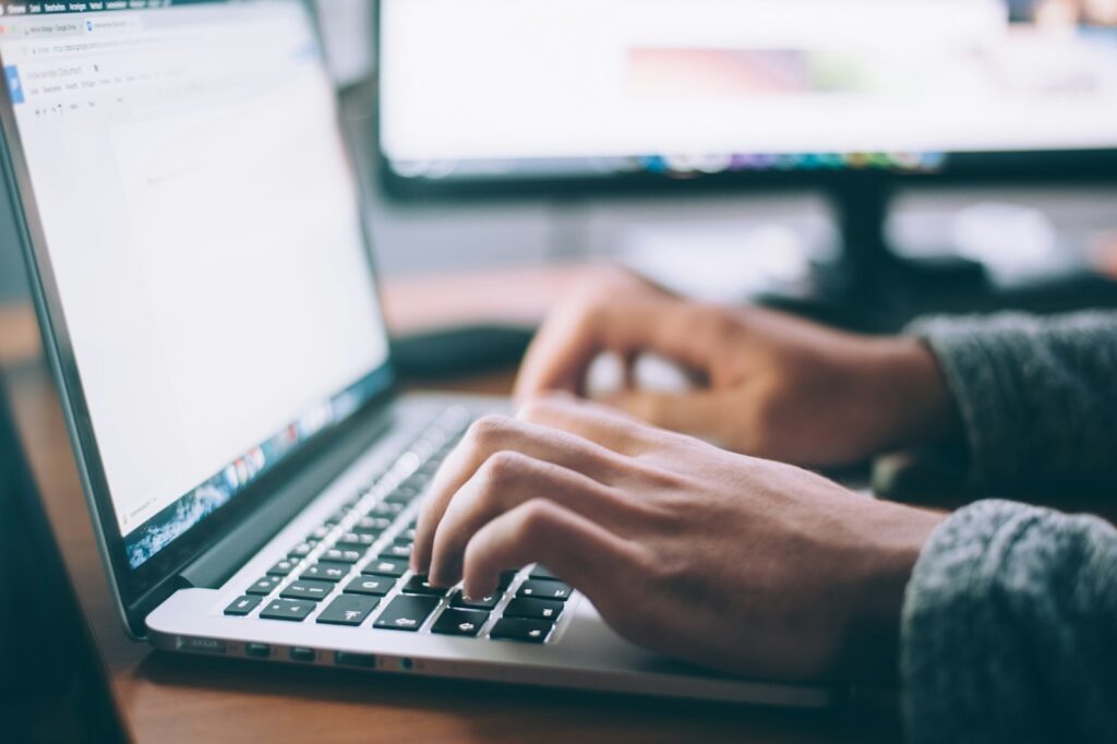 Mains qui tapent un CV sur le clavier d’un ordinateur portable