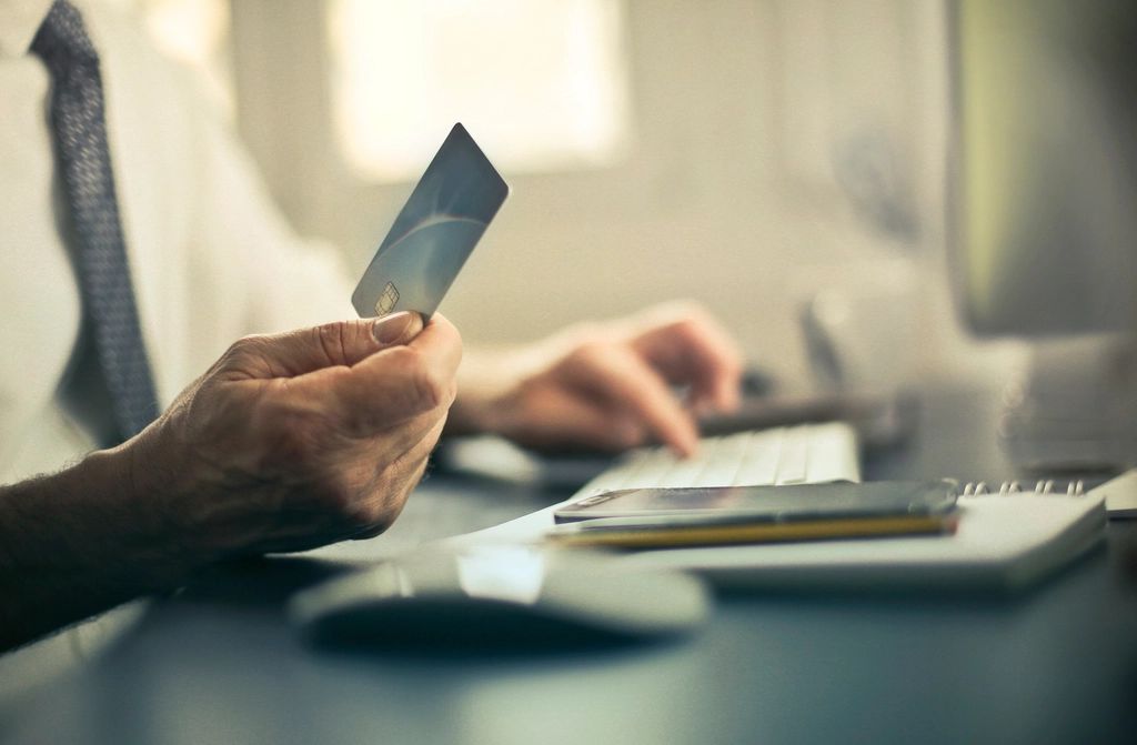 Personne effectuant un paiement par carte bancaire devant un ordinateur