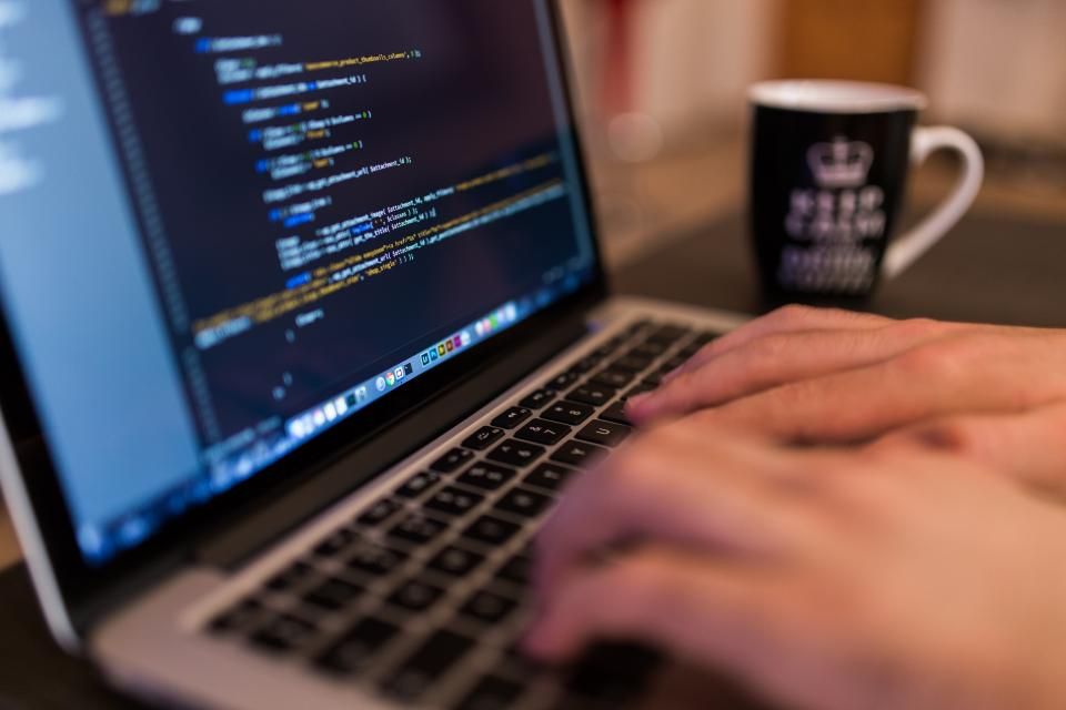 Développeur écrivant du code sur un ordinateur portable